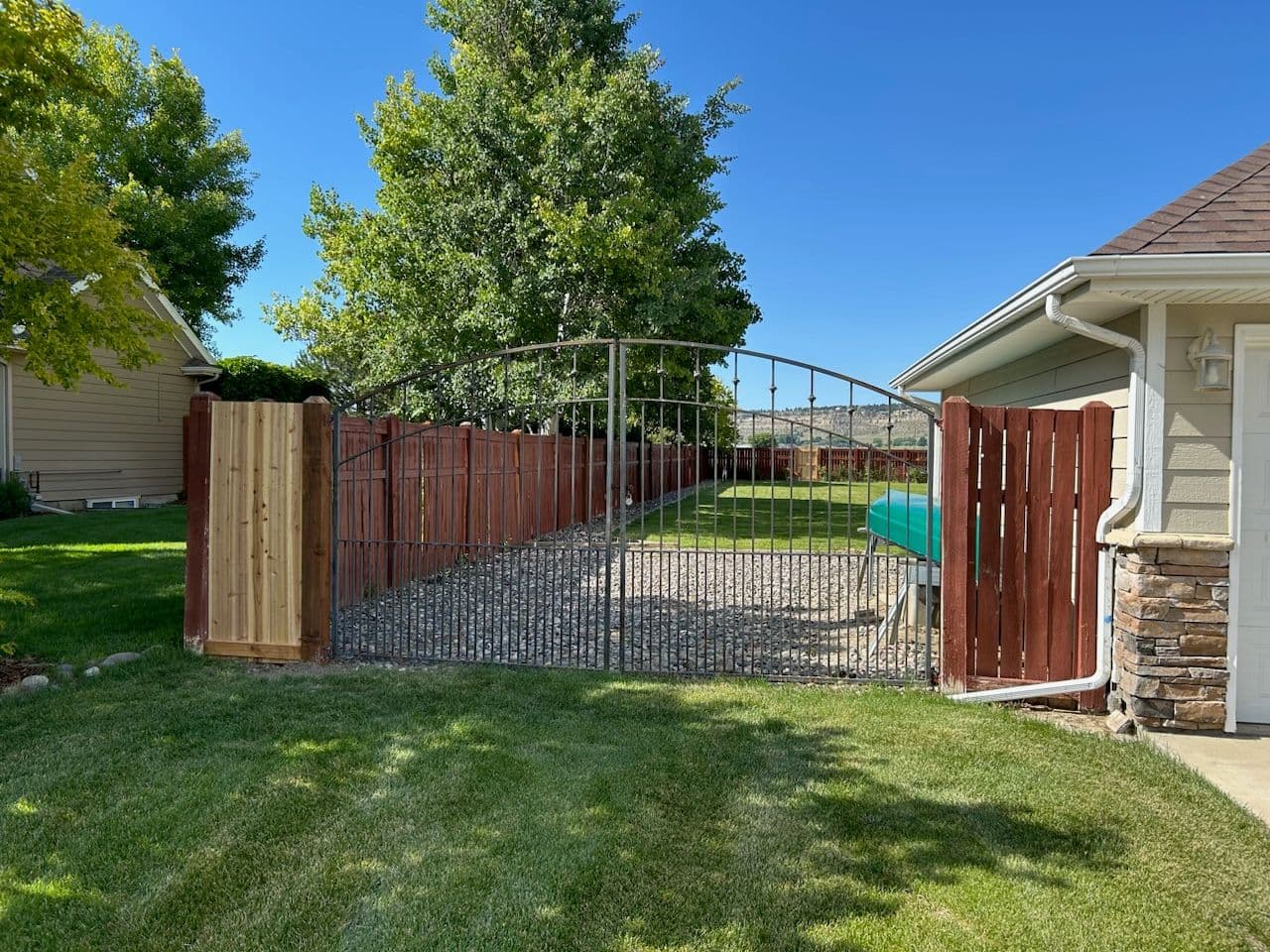 Elegant Iron Double Gate and Sturdy Wood Fence image